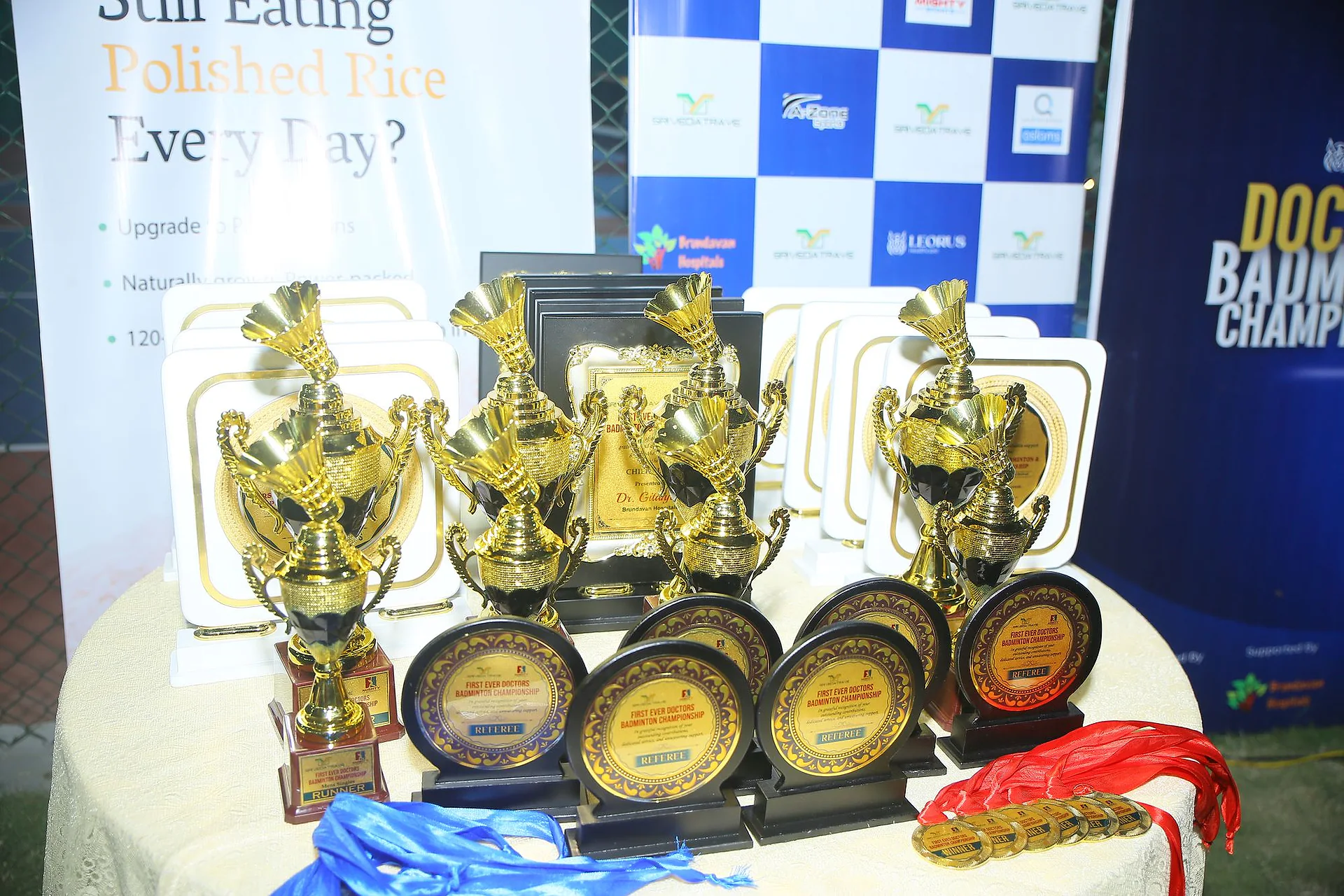 Trophies, medals and plaques laid out on a table at the Doctors Badminton Championship