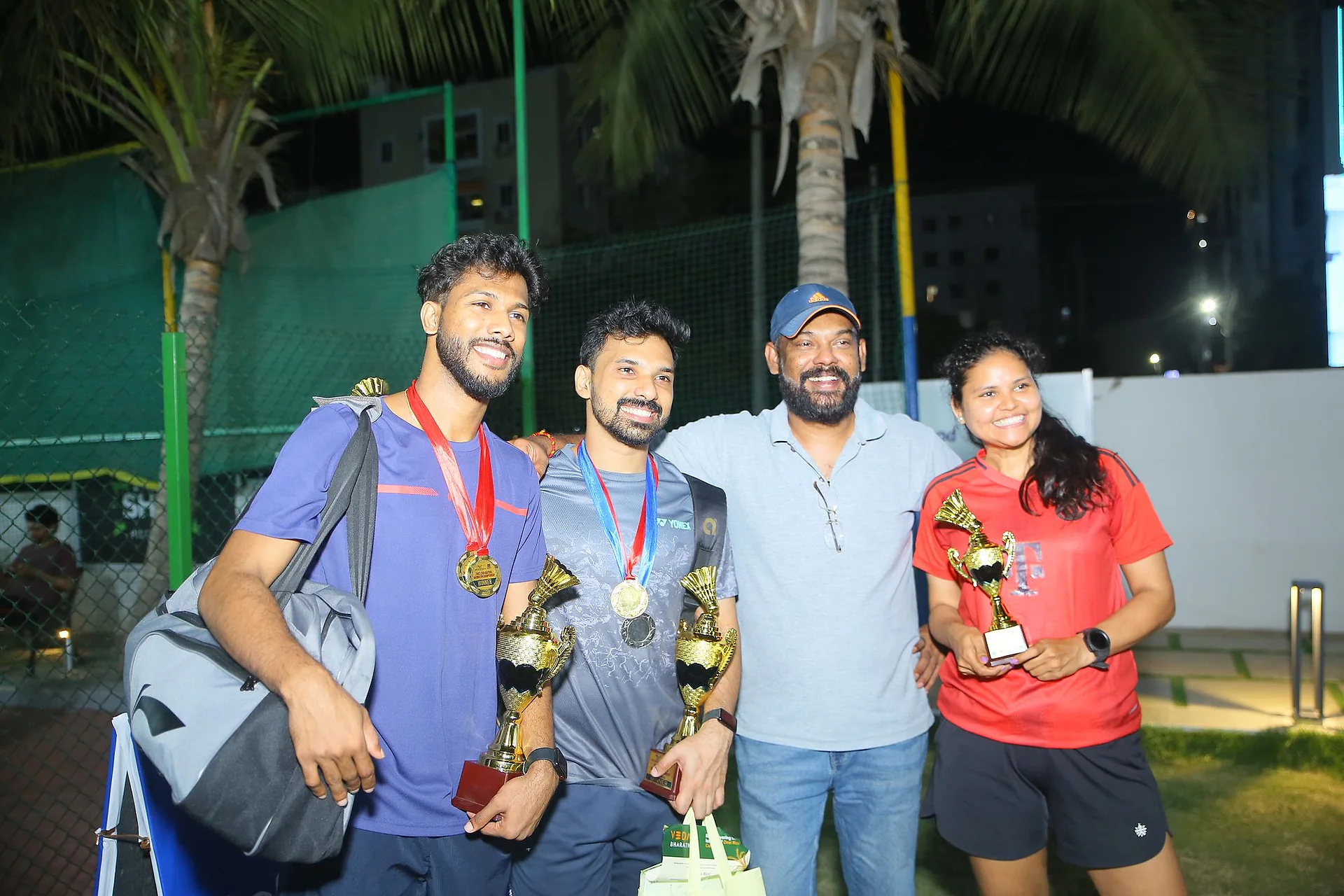 Winners with medals and trophies posing with organisers after the Doctors Badminton Championship