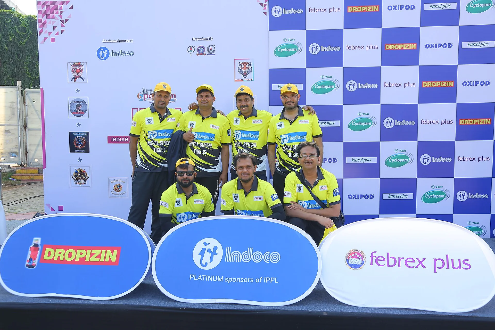 A team in yellow kit posing in front of the IPPL backdrop