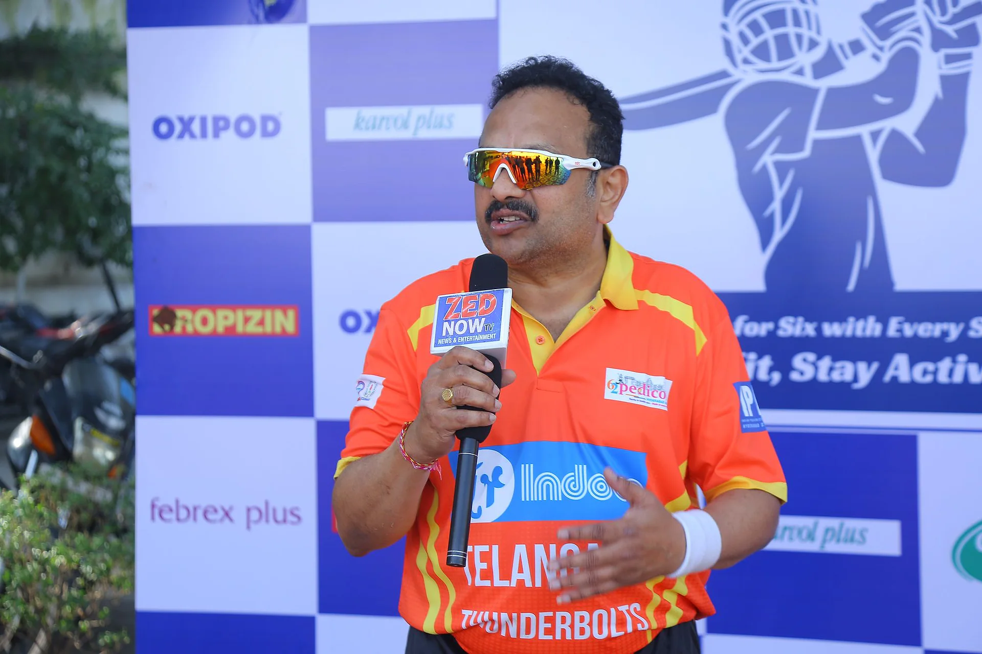A player in an orange jersey speaking into a microphone at the IPPL