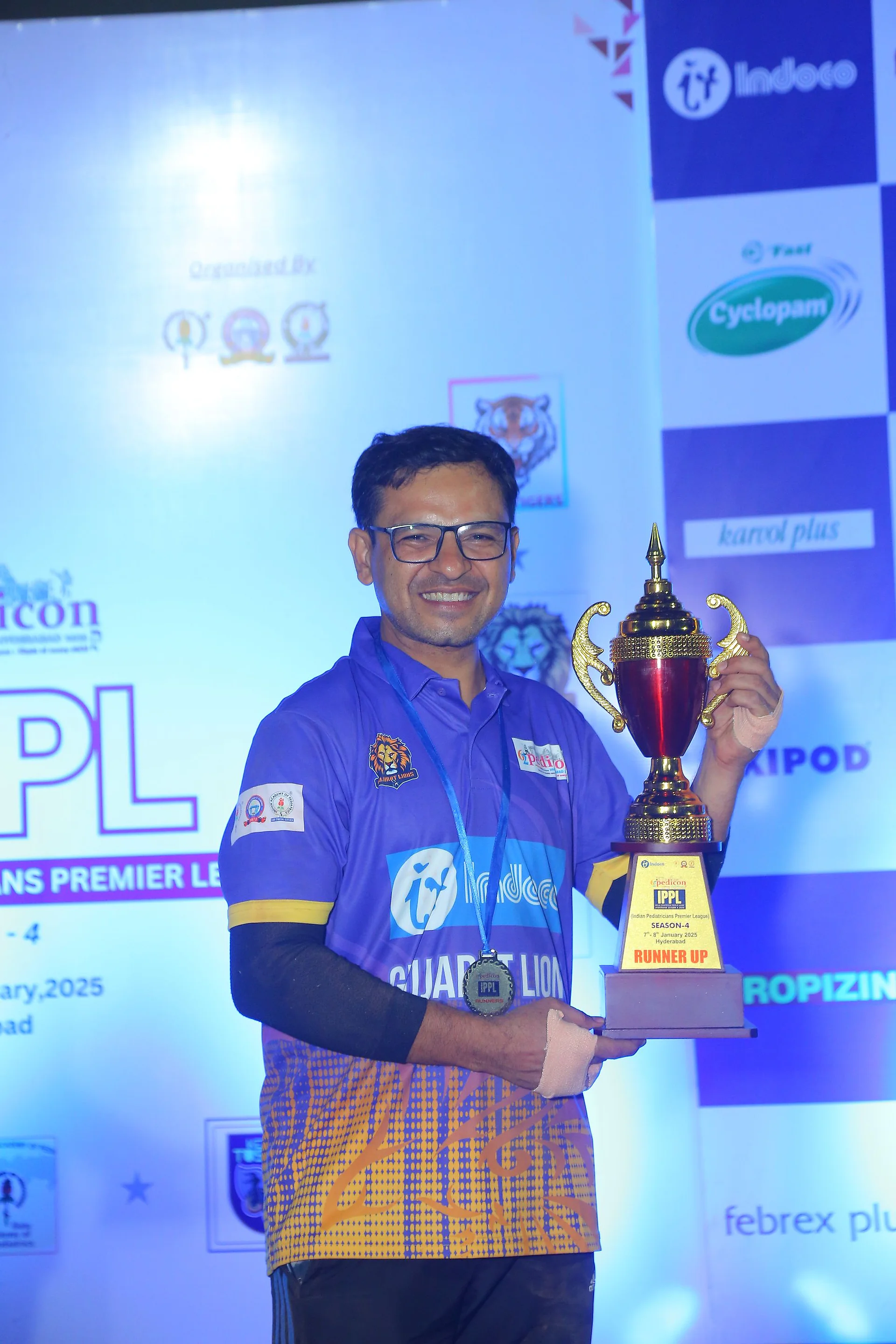 A player holding a trophy in front of the IPPL backdrop