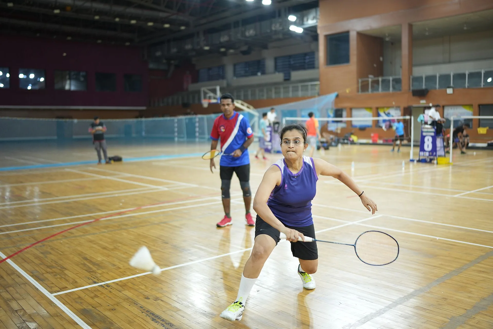 A player in a purple top diving low for a shot