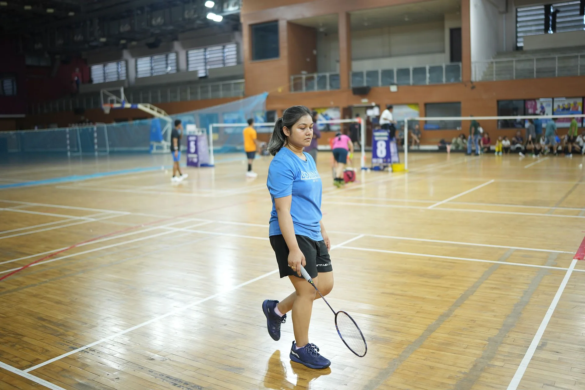 A player in a blue top moving into position on court